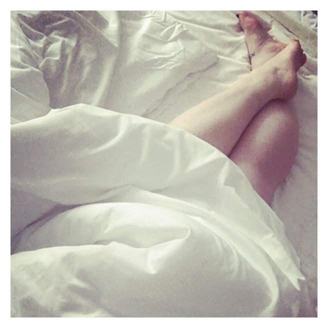 Tattooed feet in hotel bed