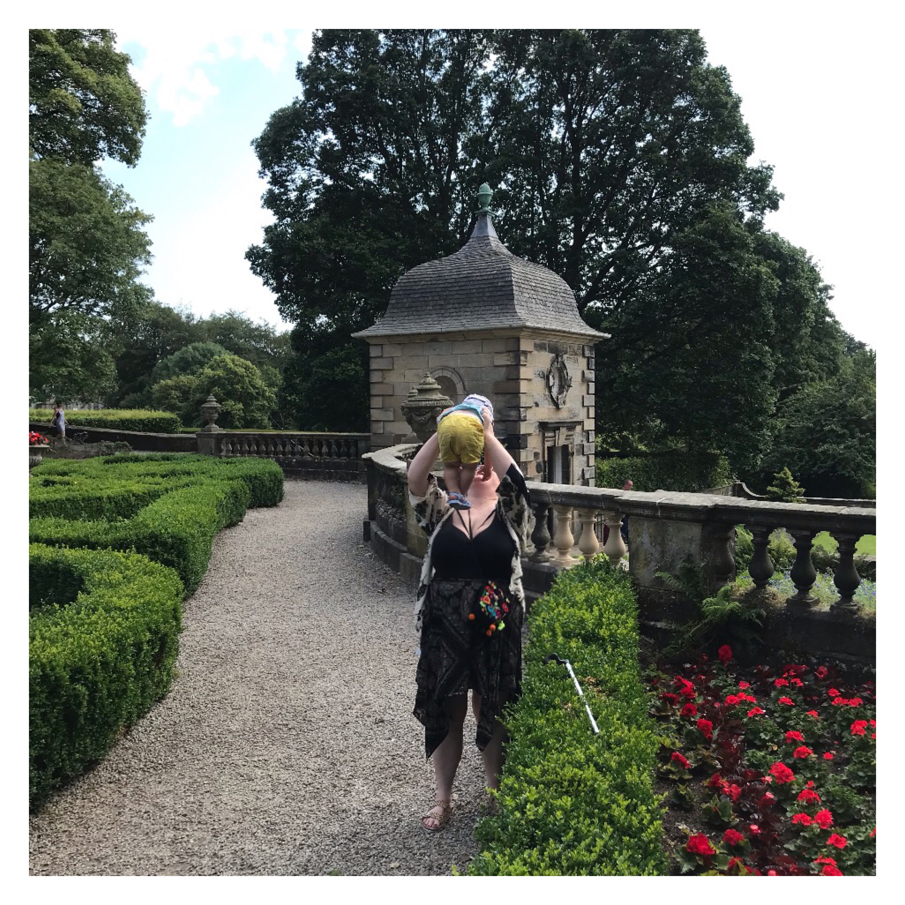 Woman & child playing in formal garden