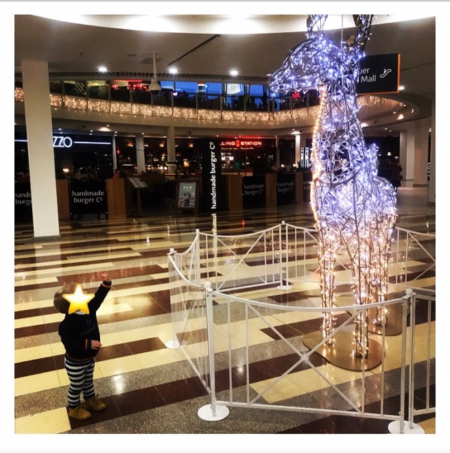 Toddler pointing up a big Xmas reindeer 