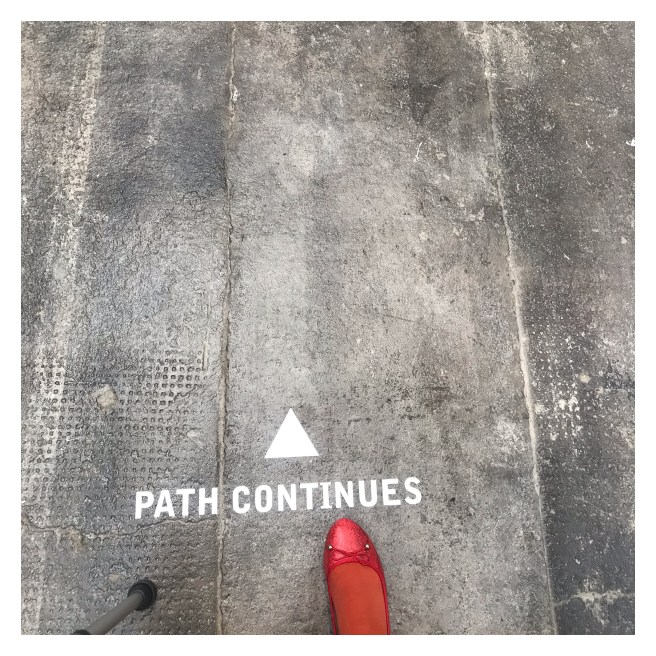 Path continued painted cement ground with foot & walking stick 