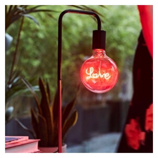 Desk last lamp with red neon ‘love’ inside large exposed bulb