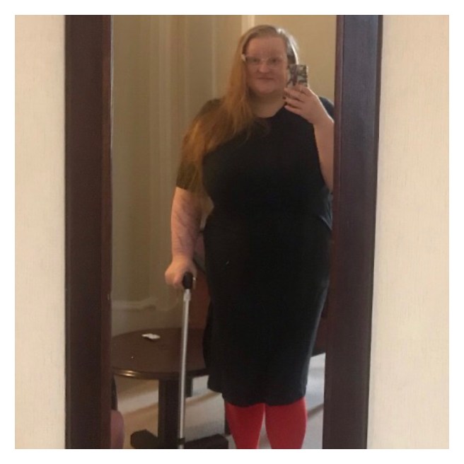 Mirror selfie of ly in black t shirt dress with walking stick 