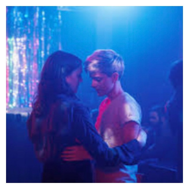 Two women dancing in neon lit room