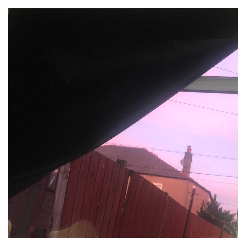 Pink sunrise through bedroom window 