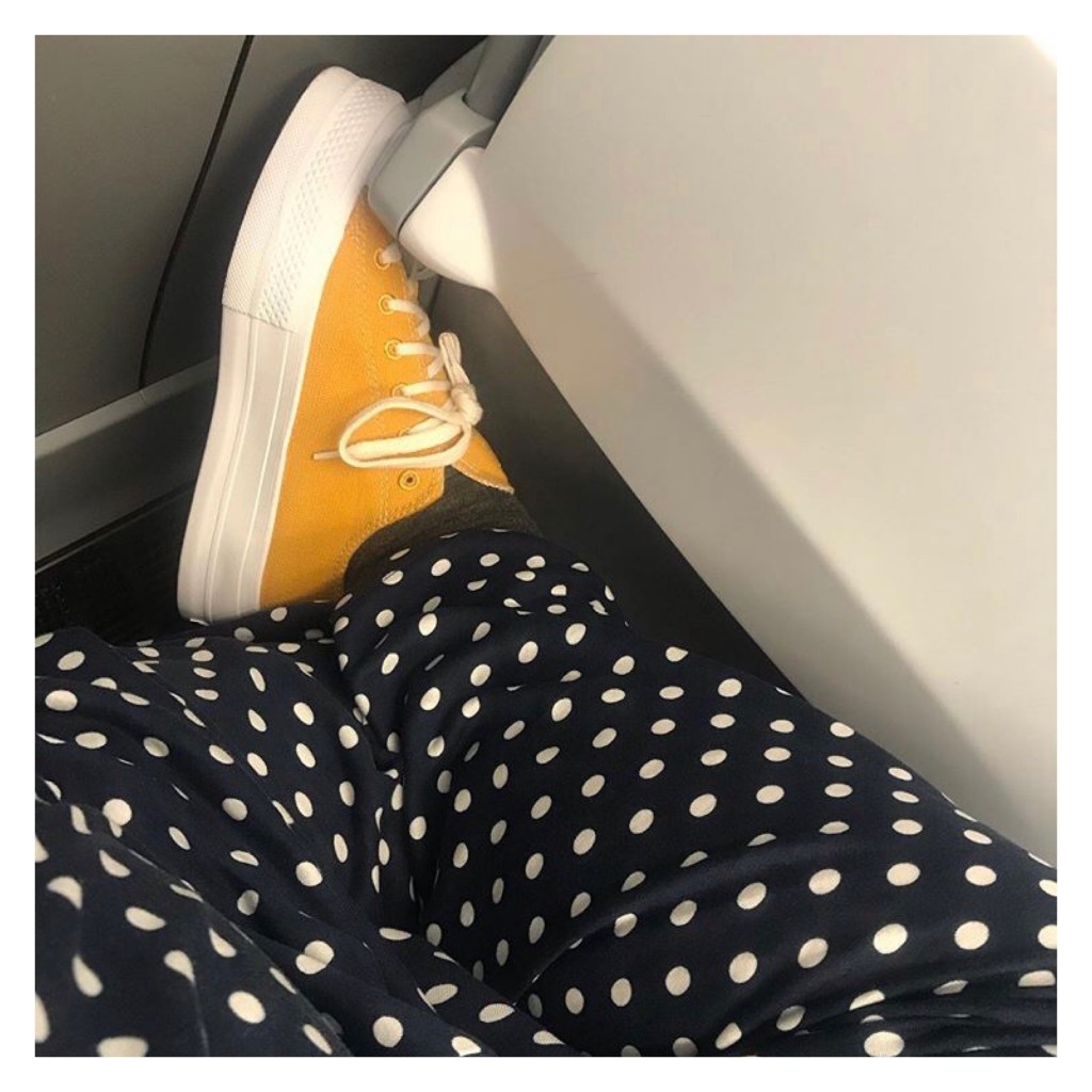 Woman’s legs wearing polka dot trs & yellow converse 