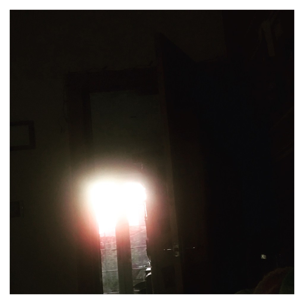 Orange light is sunset shining in to a dark room 