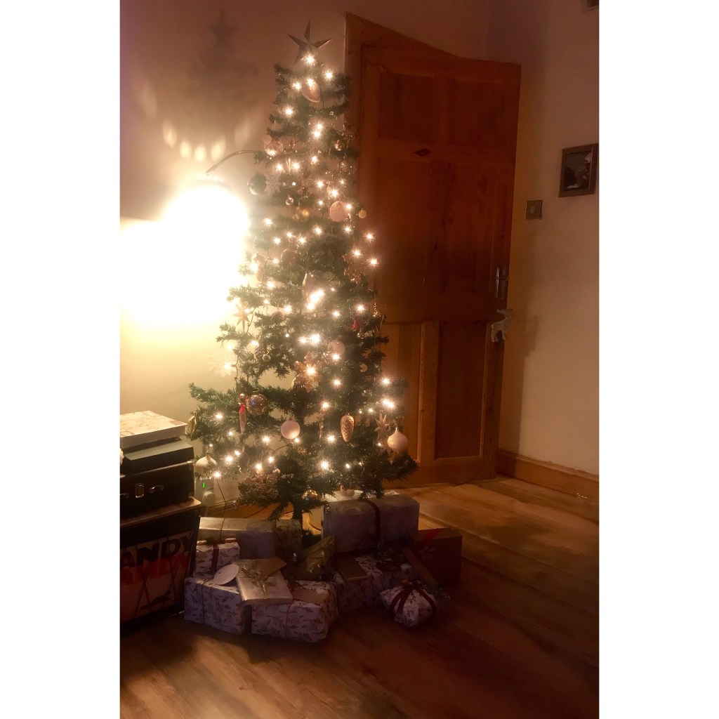 Faux green Xmas tree with white lights & gold decorations