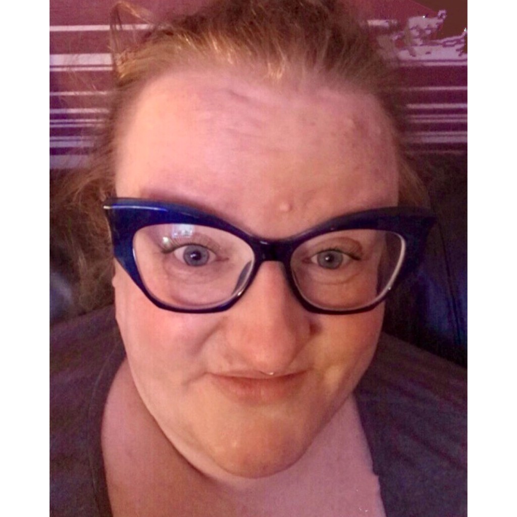 Ly is wearing blue cateye glasses and smiling 