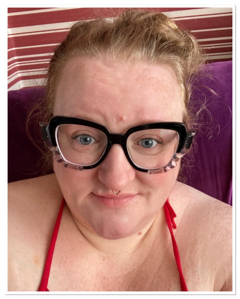 Ly is wearing thick black framed glasses with silver detail 