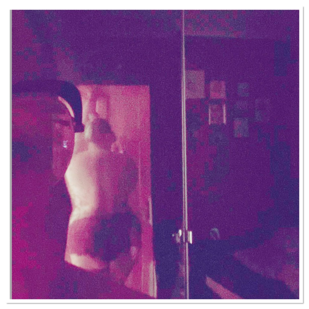 ly is taking a pic of herself over her shoulder in a mirror wearing burgndy pants  