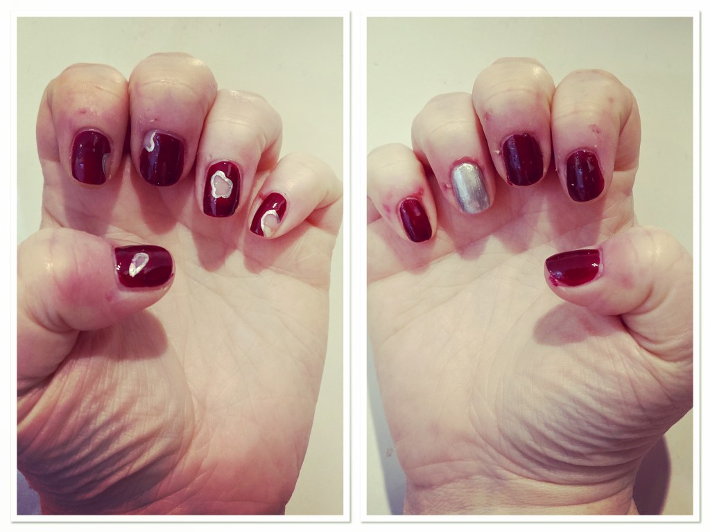 Two hands showing deep red and silver manicure