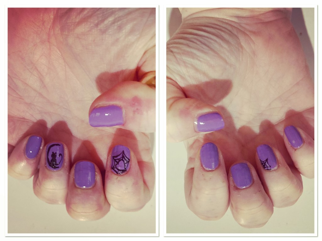 Hands with lilac manicure with black crescent moon,  cat & spider web 