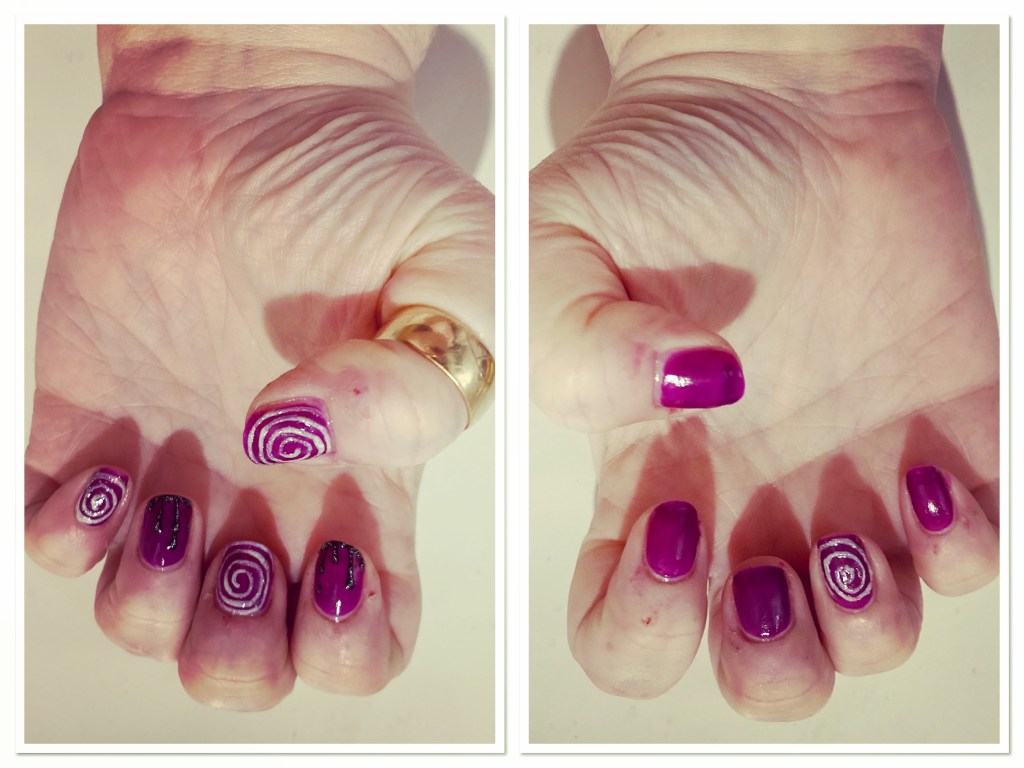 Park white hands with purple manicure with white swirls and glittery black drips 