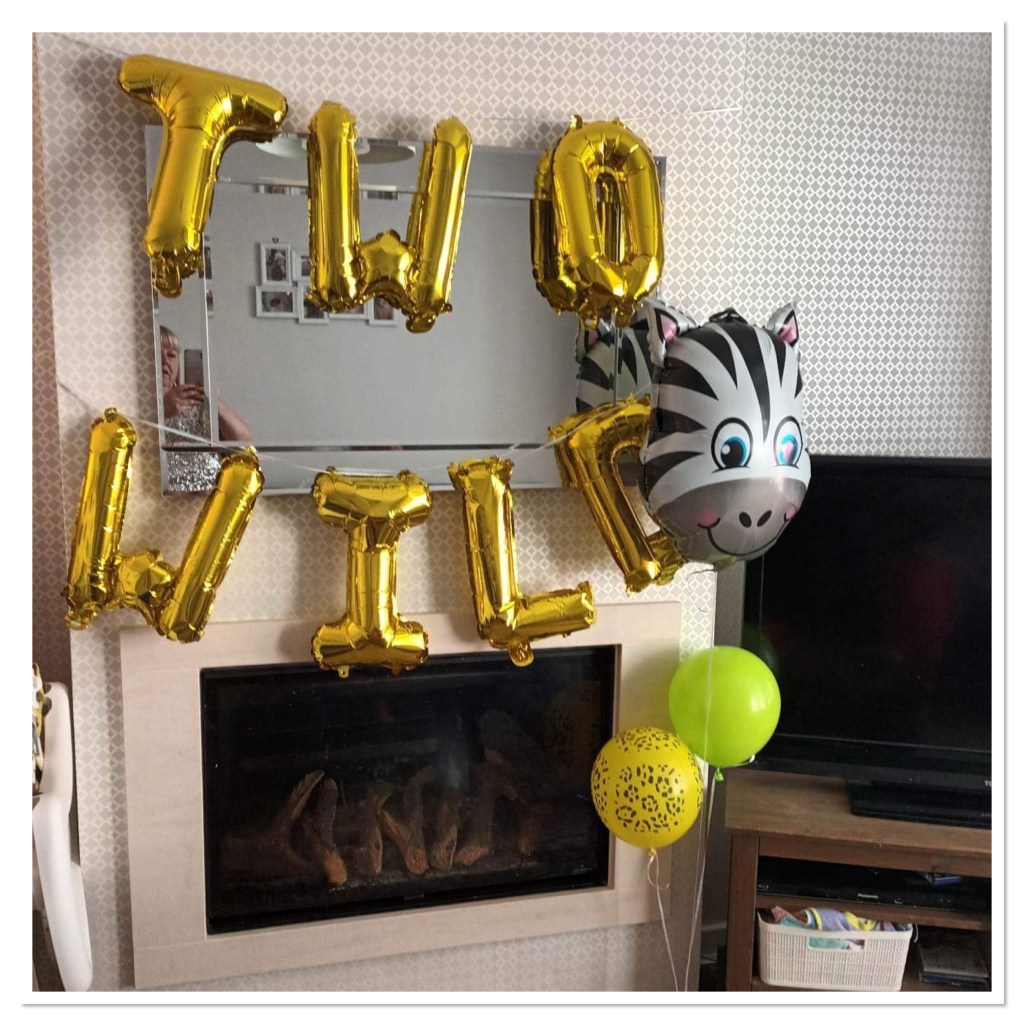 Gold letter Balloons spelling out two wild and a zebra balloon. 